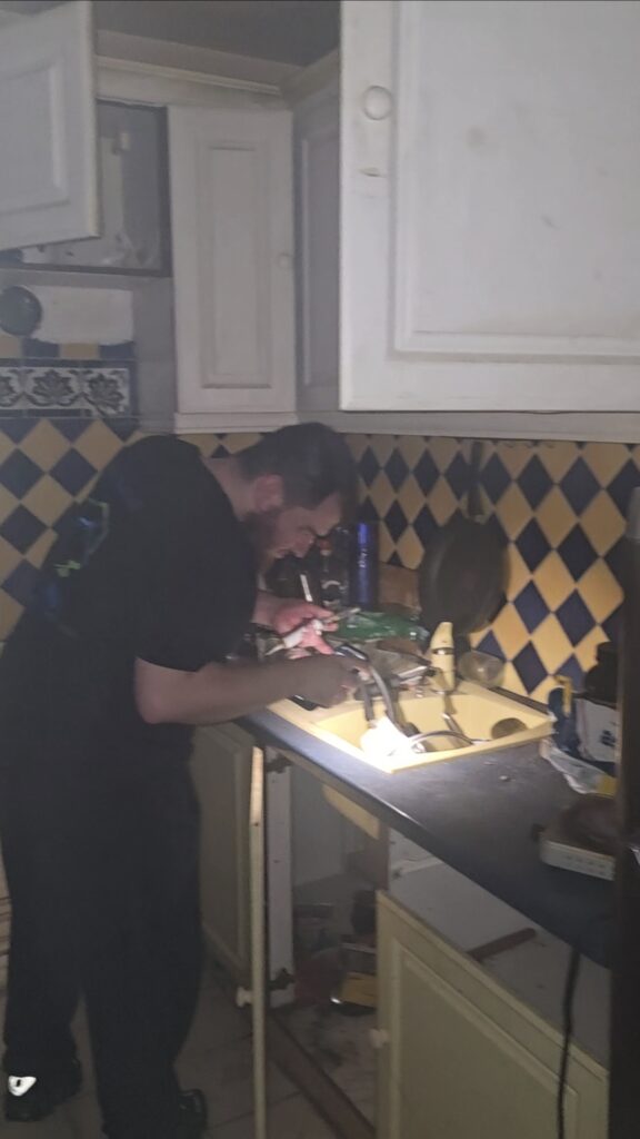 Technicien IJN+ appliquant un gel insecticide sur un plan de travail de cuisine, lors d'une intervention contre les cafards à Asnières-sur-Seine
