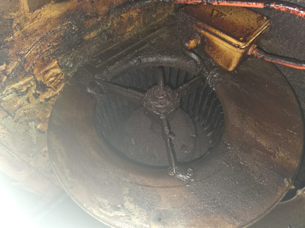 Turbine du moteur d'extraction entièrement recouverte de dépôt de graisse brune, dans un restaurant de Cergy