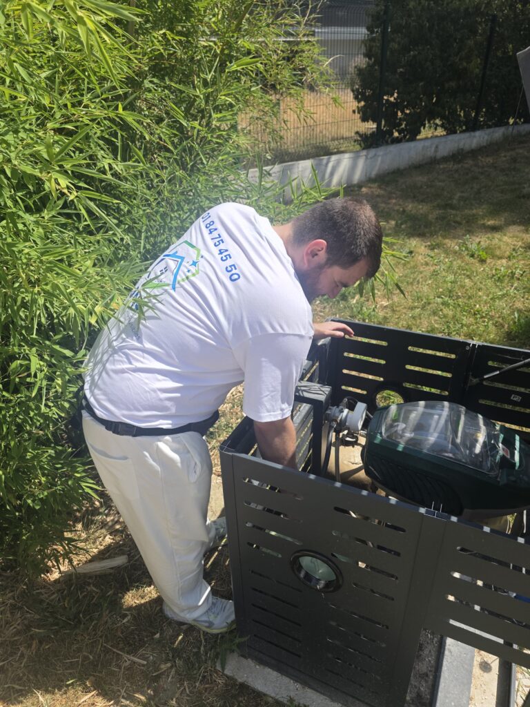 Technicien IJN+ en polo blanc effectuant la maintenance d'un Mosquito Magnet installé dans un espace vert